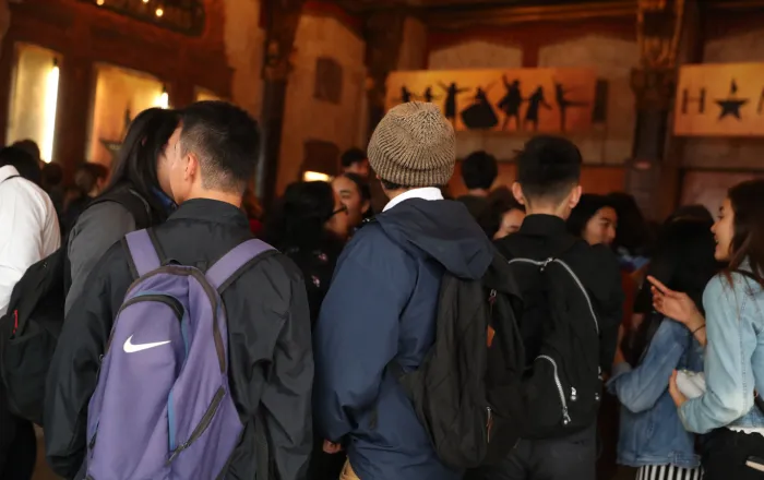 Students with abckpacks lining up outside the theater